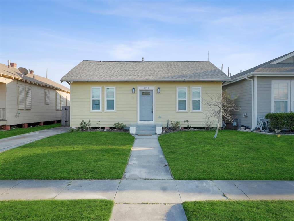 Charming single-story home with a neat facade and well-maintained lawn. Features a welcoming walkway leading to the front door and is situated between two neighboring houses.