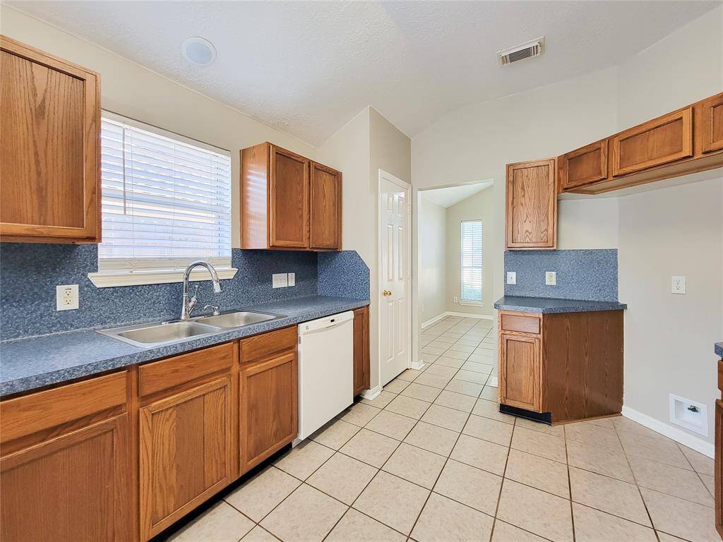 Elegant tile flooring seamlessly connects the dining area, foyer, kitchen, and breakfast areas.