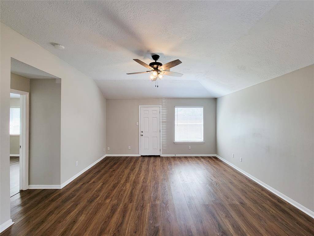 Den boasts laminate wood floors and upgraded ceiling fan and light fixture.  Door to private backyard.