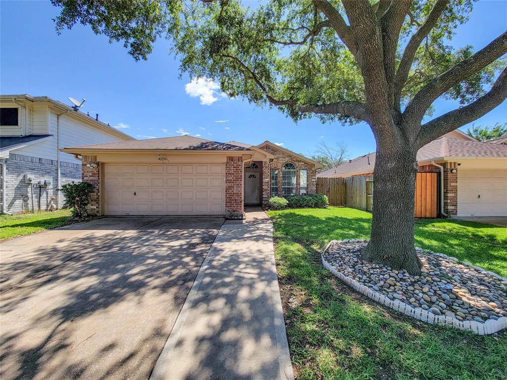 Ample parking with a double-wide driveway and two-car garage, plus an extra concrete path for easy home access.
