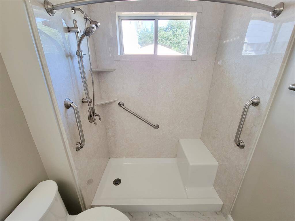 Spacious primary bath features a luxurious step-in shower with a built-in bench.