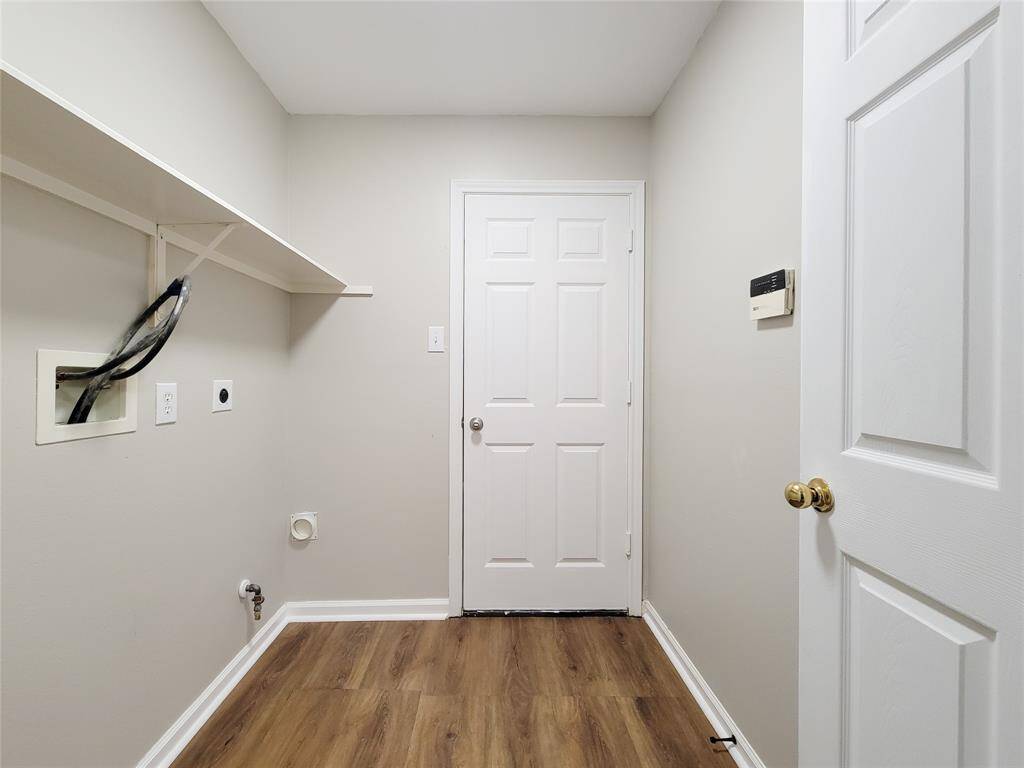 Convenient utility room with garage access, equipped with gas and electric dryer connections plus overhead shelf for storage.