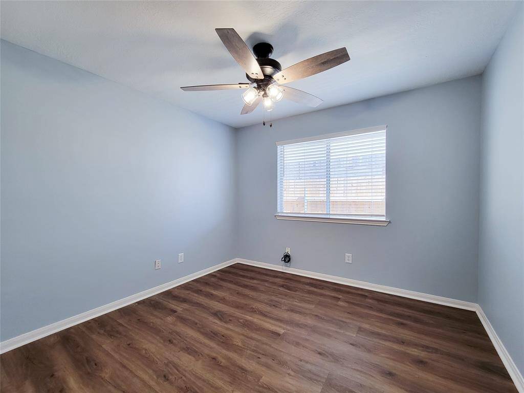 Stylish second bedroom featuring a modern ceiling fan and light fixture.
