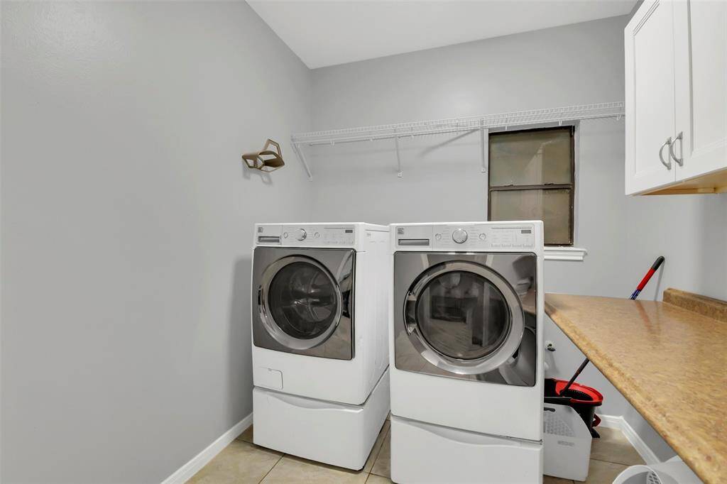 Laundry room with storage and cabinets.