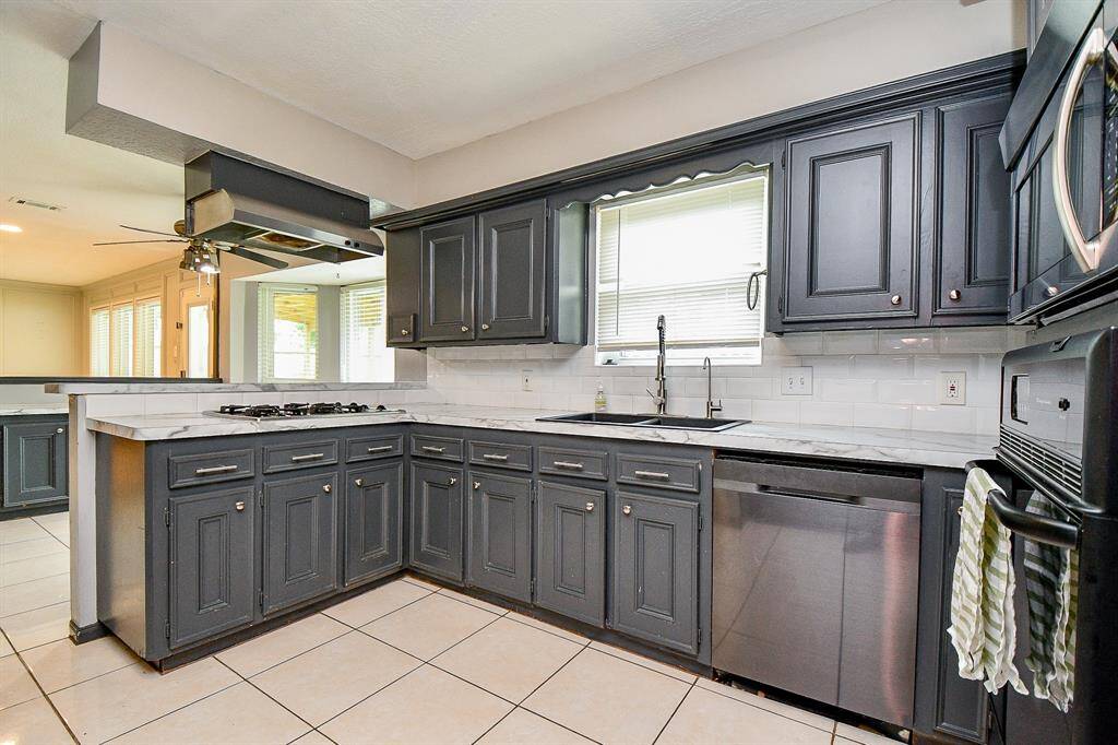 Sleek gray cabinetry sets the tone for a sophisticated space, complemented by pristine white countertops that offer both elegance and practicality.