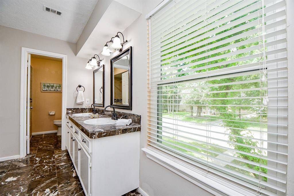 Window with  blinds lets in soft natural light, adding brightness to the space.
