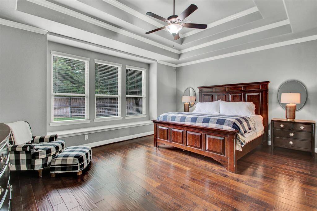 1st floor primary suite with engineered wood floors, a fabulous view of the backyard through the wall of windows, and another ceiling with incredible detail!