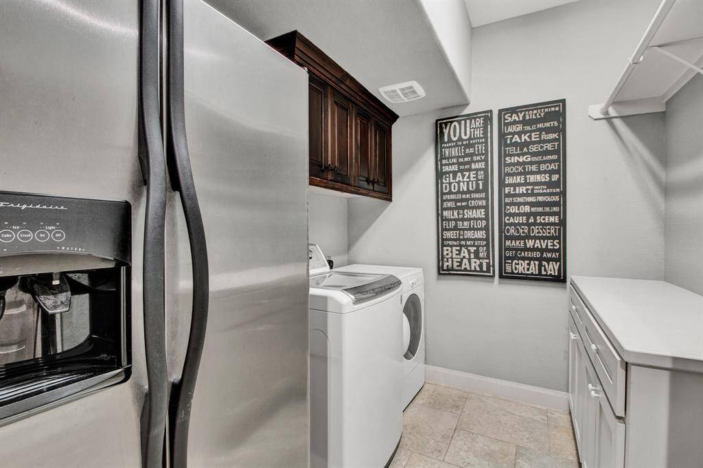 Spacious laundry room with extra built-in cabinets and counters, plus room for an extra fridge.