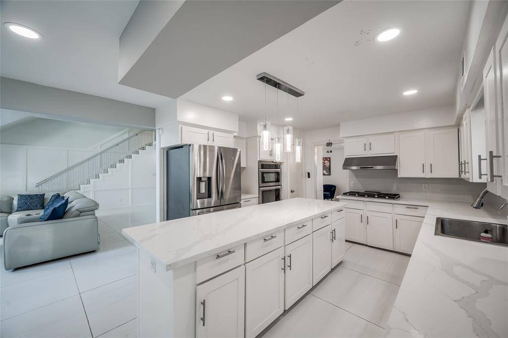The kitchen boasts modern appliances and ample counter space, while the adjacent breakfast area offers a cozy spot for casual dining and morning gatherings. This combined space fosters a welcoming atmosphere where family and friends can gather and enjoy time together, making it the heart of the home.