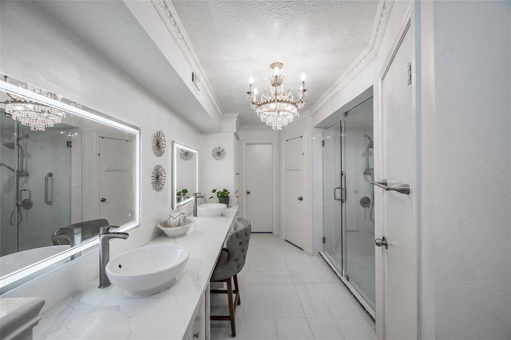 Indulge in luxury in this exquisite en-suite bath, designed for both elegance and functionality. The space features double sinks, offering ample room for both partners to have their own area. His and her zones ensure privacy and convenience, while the sleek glass shower provides a modern touch and a spa-like experience. High-quality finishes and thoughtful details complete this sophisticated retreat, making it the perfect place to start and end your day in comfort and style.