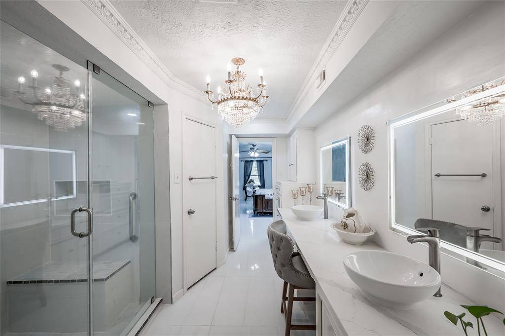 The double sinks, offers convenience and ample room for personal care. The sleek glass shower adds a modern touch and provides a refreshing retreat. High-end finishes and meticulous attention to detail create a spa-like atmosphere, making this en-suite bath a perfect blend of comfort and sophistication.