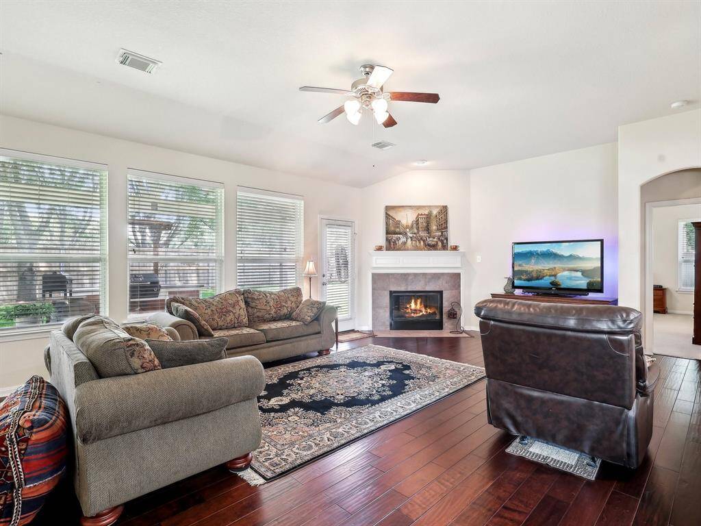 This lovely Family Room has wood flooring and a corner fireplace to set the mood or warm a chilly night.
