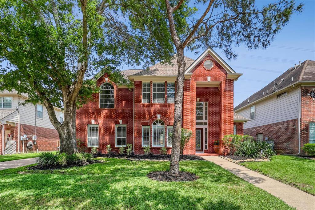 Welcome to 6207 Presidio Canyon Drive, nestled in the gated community of Canyon Gate at Cinco Ranch. This home makes a striking first impression with its classic brick exterior, expansive windows, and beautiful mature trees that enhance its curb appeal.