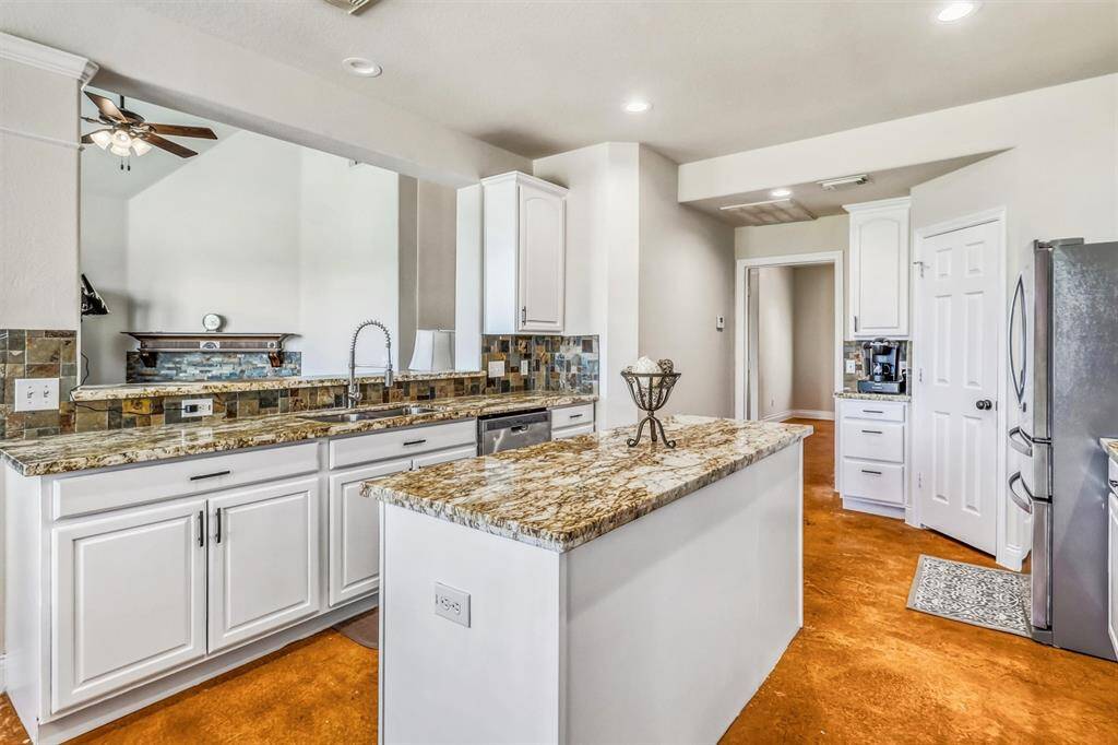 The undermount sink, featuring an upgraded faucet, is positioned just below the breakfast bar, creating an open layout that fosters easy conversation and seamless entertaining. The dishwasher is conveniently located to the right of the sink for added efficiency.