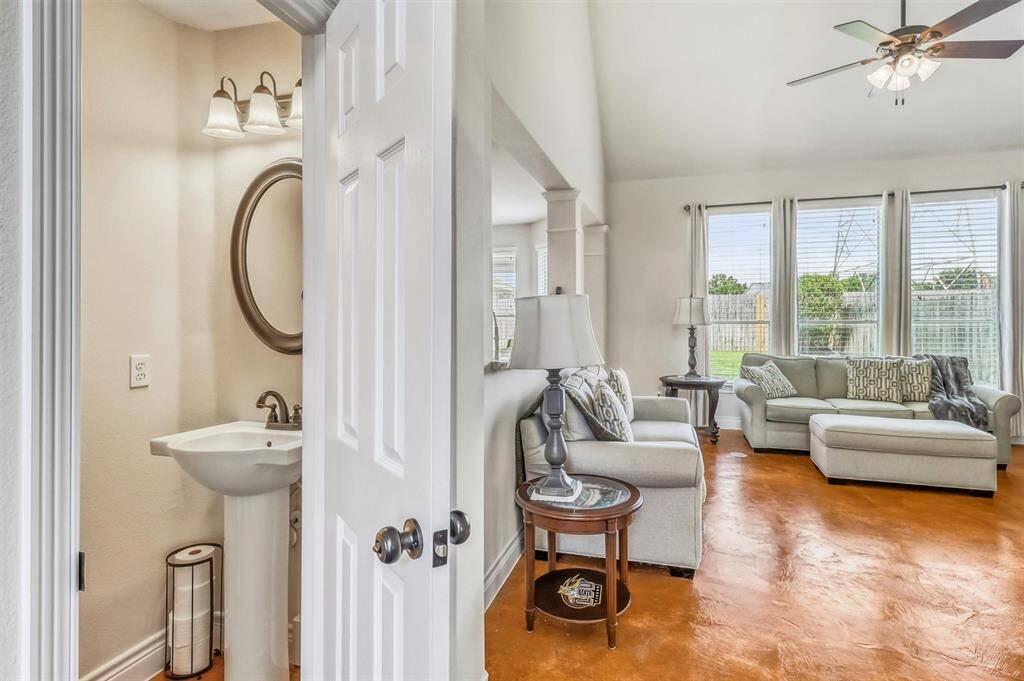 Conveniently located between the living room and entryway, the half bathroom features a classic pedestal sink and a stunning framed mirror.