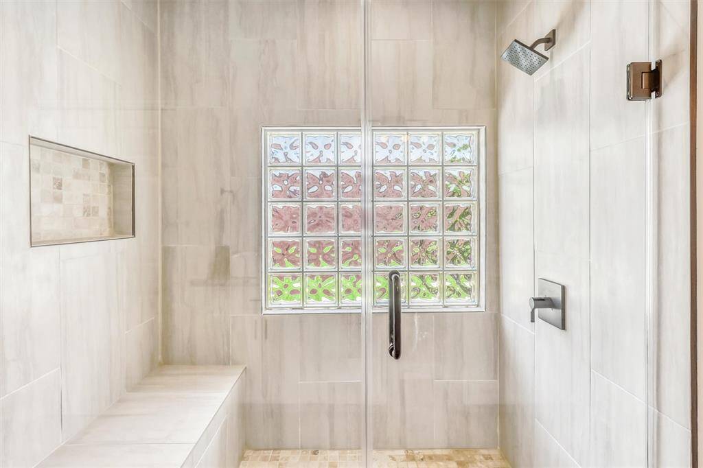 The shower also features an obscure window, offering privacy while still allowing natural light to fill the space. Updated finishes and a modern showerhead complete the luxurious, spa-like experience.