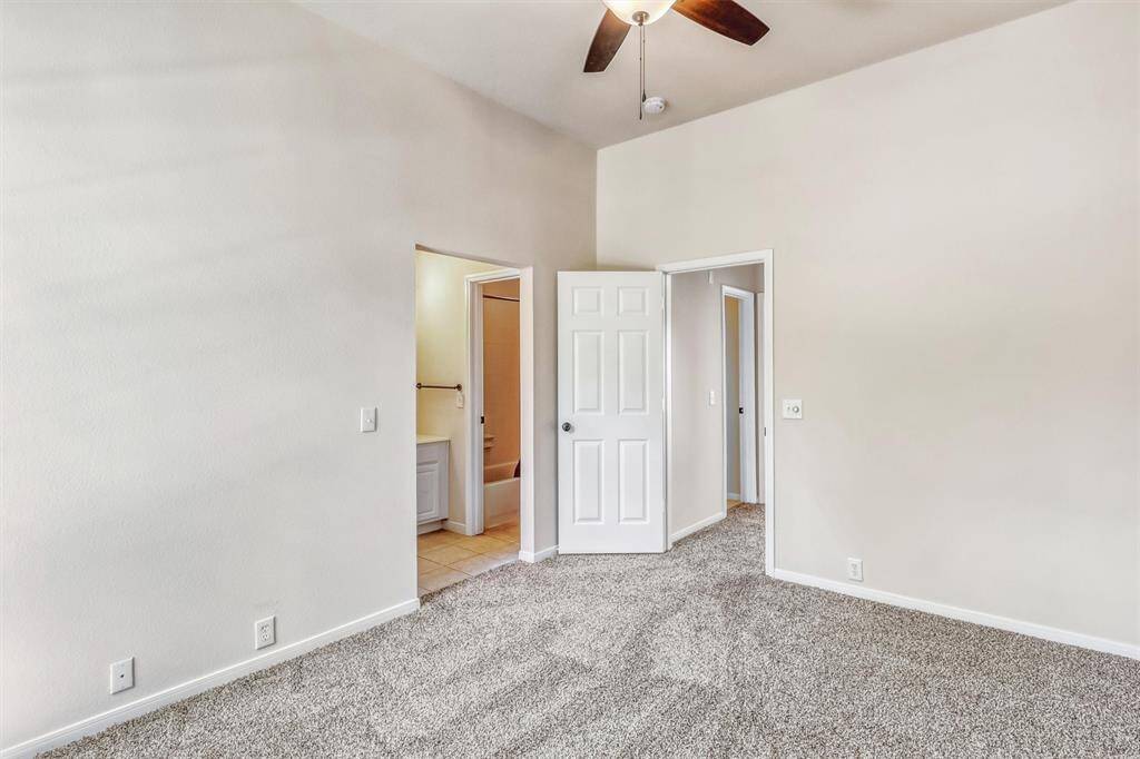 This bedroom offers direct access to a vanity and shared bathroom, adding convenience and functionality to its comfortable layout.