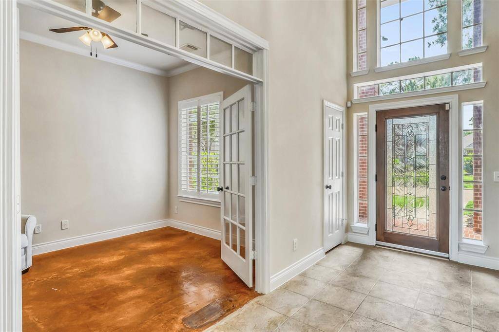 Just off the entryway, a private study awaits—enclosed by French doors with a transom window for added light and charm. Thoughtful details like crown molding, plantation shutters, and a ceiling fan enhance both style and comfort.