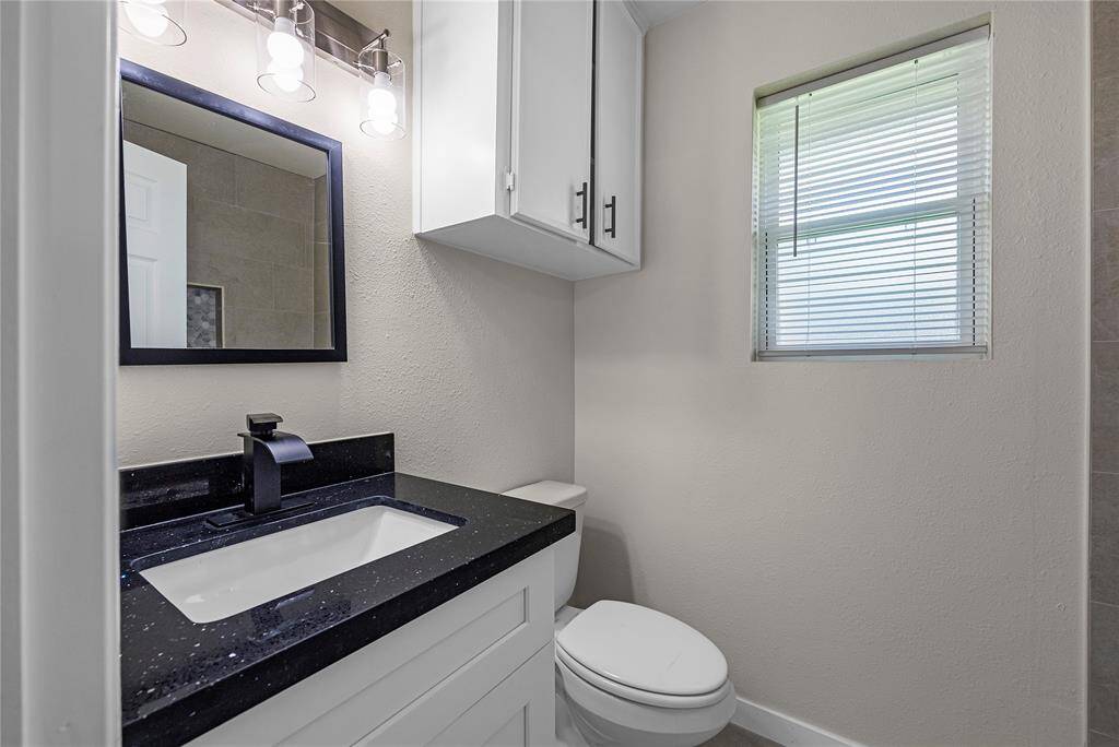 This bathroom boasts a modern vanity with a black faucet and a clean, neutral color scheme.
