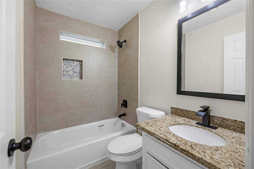 Spacious bathroom with a comfortable soaking tub and a stylish vanity.