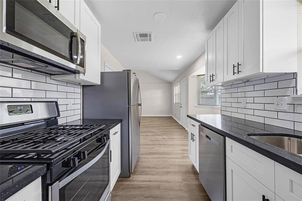 Stylish white cabinetry and black granite countertops create a striking contrast.