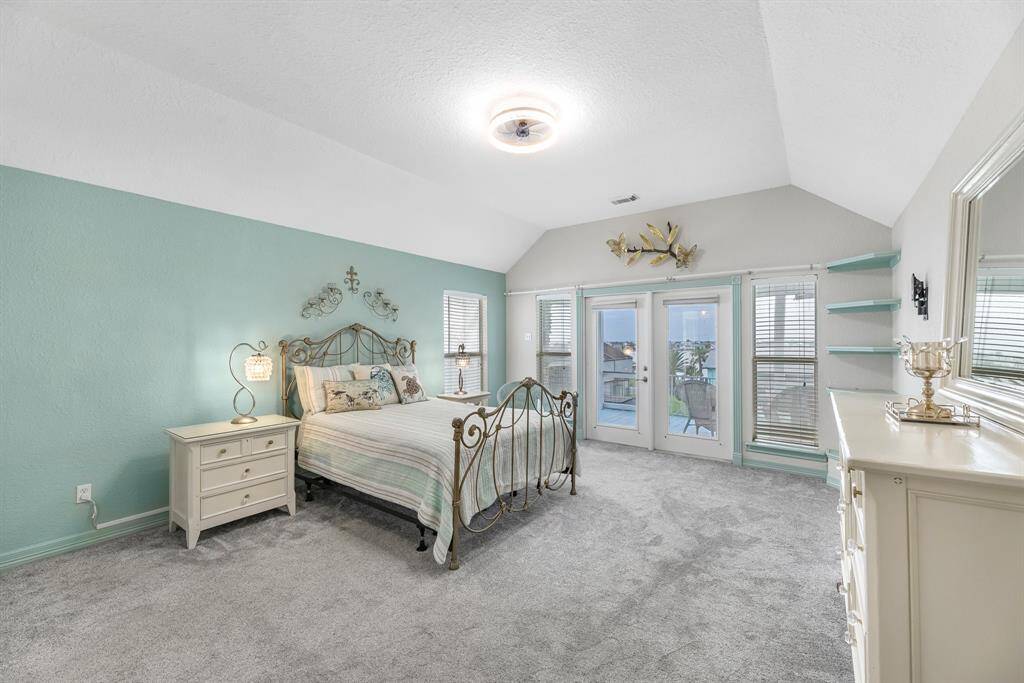 Spacious primary bedroom with French doors opening to a private balcony.