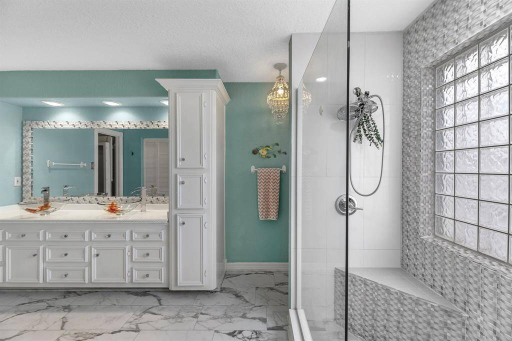 Luxurious primary bath with a spacious walk-in shower and elegant double sinks.