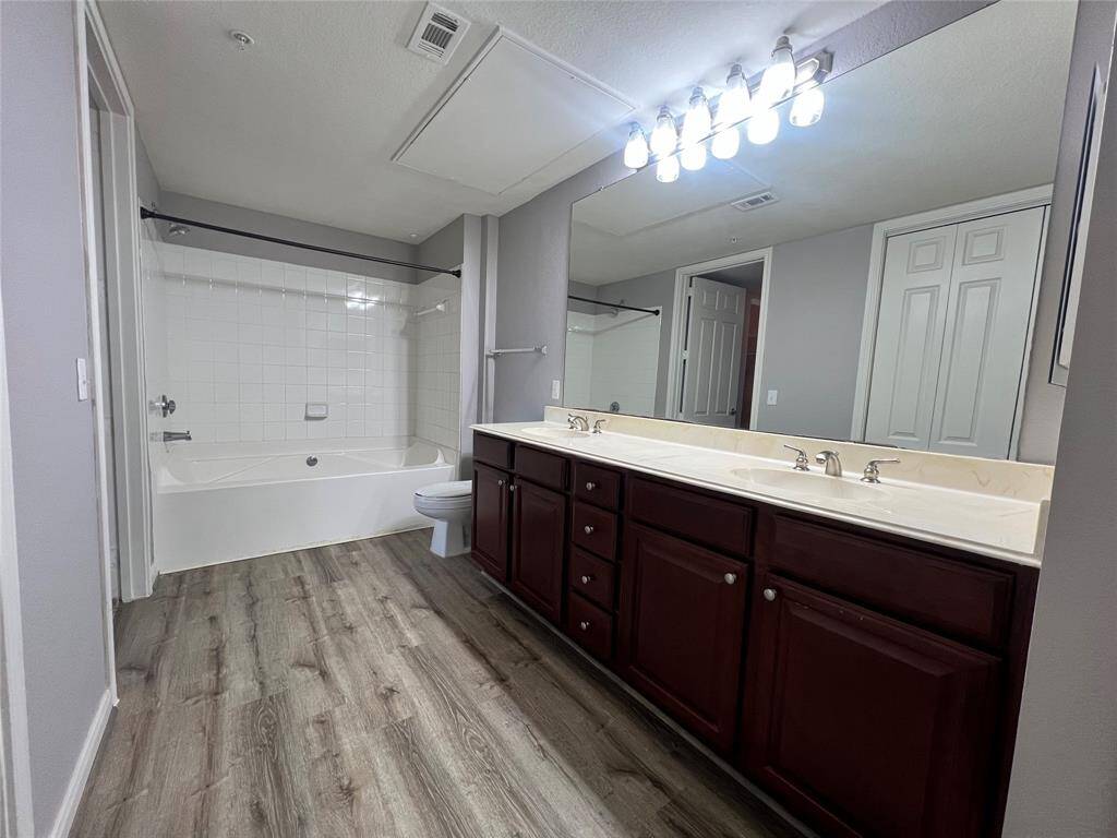 The spacious bathroom includes vinyl plank flooring, double sinks, soaking tub and LOTS of storage.