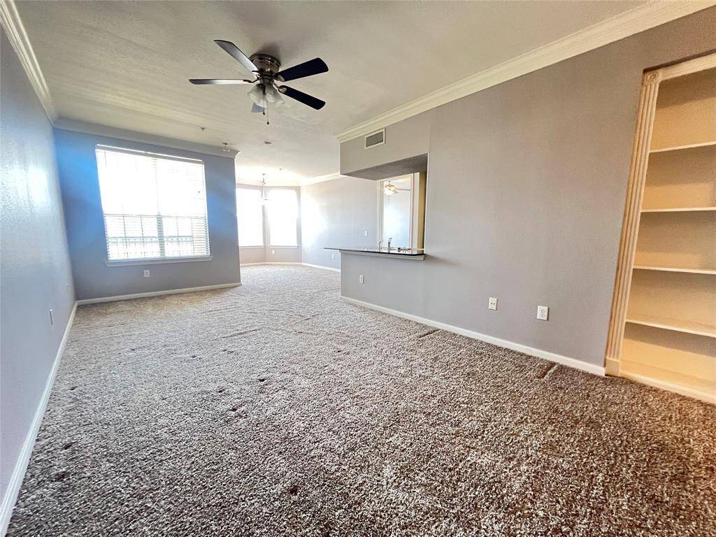 This condo is located on the 2nd floor. As you walk in you are greeted by an oversized living space with built-in bookshelves.