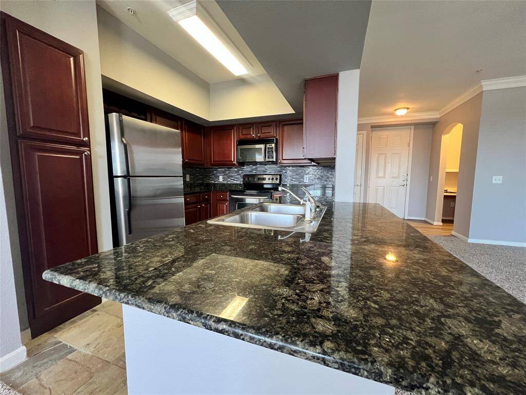 The kitchen includes slate floors, granite counters, tile backsplash and stainless appliances.