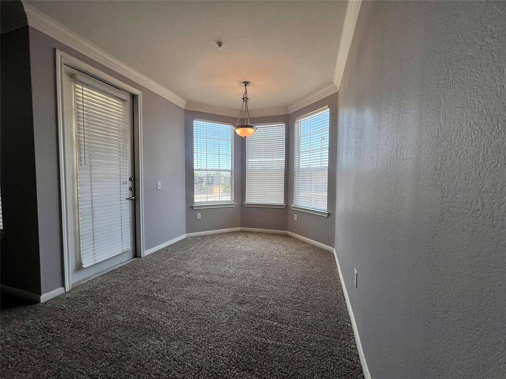 The dining area with a bay window can accommodate a large dining table. The door leads out onto the patio.