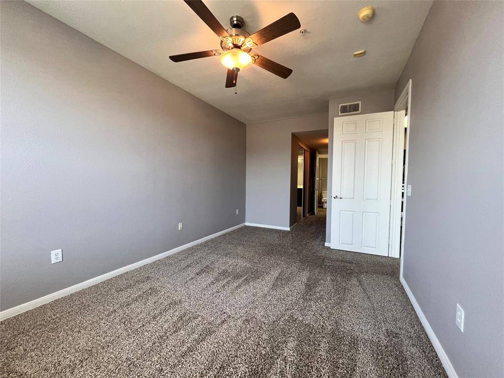 This view of the bedroom is looking toward the hallway where you see the large walk-in closet and bathroom.