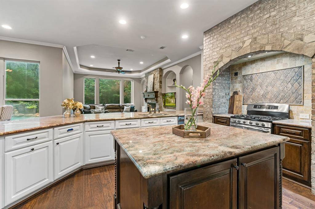 Kitchen features white cabinets with contrasting stained island.