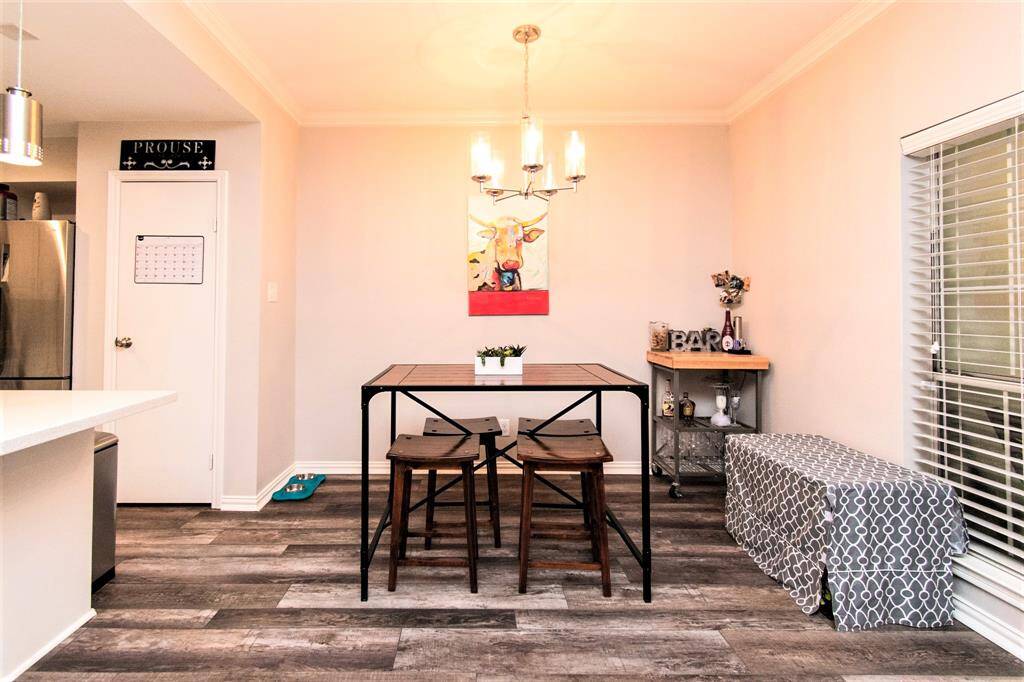 The wood flooring compliments the Dining table and the white painted wall finish