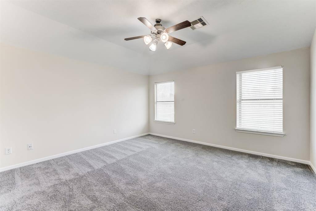 Primary BedroomSpacious primary suite with plush new carpet, natural light, and a ceiling fan for added comfort.