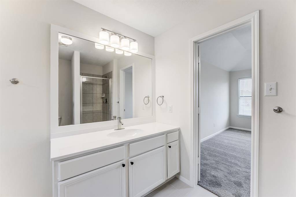 Relax in the upgraded guest bath featuring a large vanity with fresh white cabinetry, a soaking tub, and updated lighting.