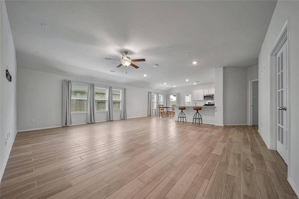 The Kitchen Features Gas Cooking, a Built-In Microwave, High Ceilings, Recessed Lights, and the Refrigerator is Included!