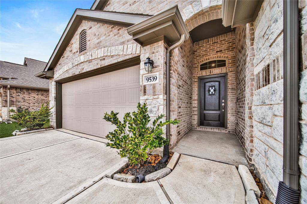 A Large Covered Front Porch, Brick and Stone Elevation, and a SpeakEasy Door Add to the Gorgeous Curb Appeal this Home Offers.