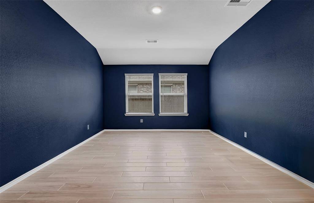 The Grand Sized Family Room Opens Nicely to the  Kitchen. This Room Showcases the High Ceilings, Recessed Lights, Blinds, and Beautiful Wood-Look Tile Flooring Found Throughout the Home Except for the Carpeted Bedrooms.