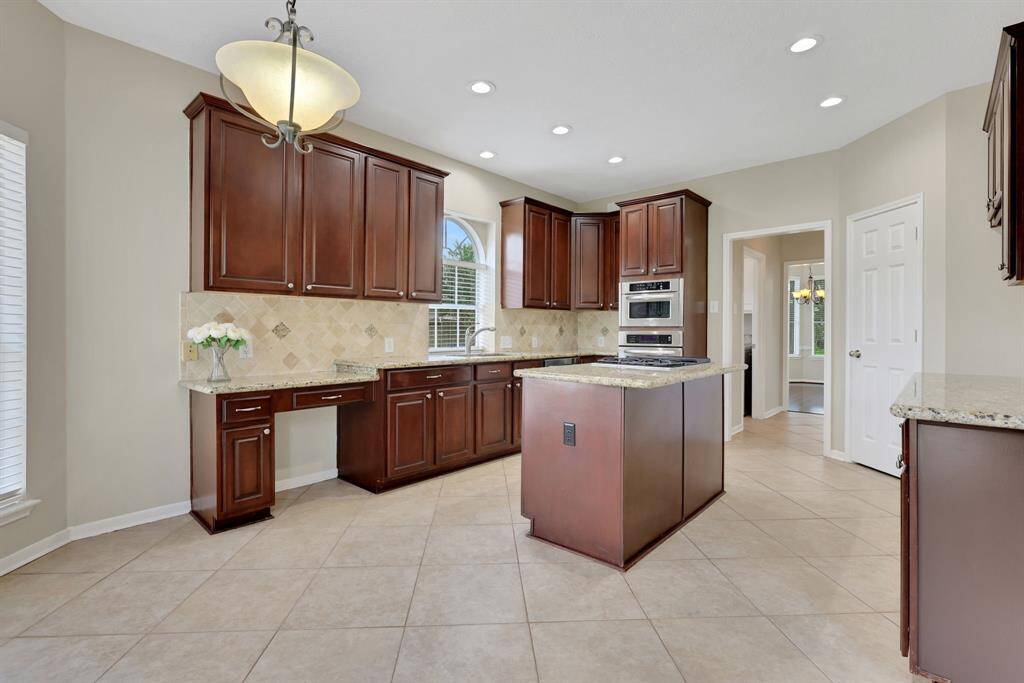 Spacious island kitchen with ample cabinet storage, a walk-in pantry, and sleek stainless steel appliances.