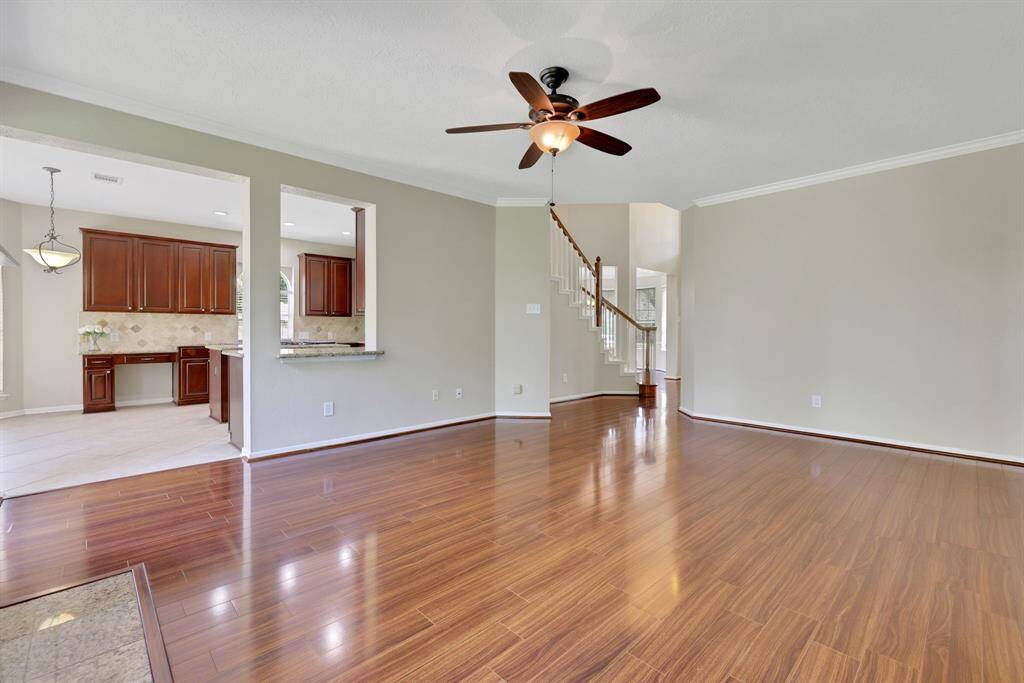 Spacious living room filled with natural light, featuring a cozy fireplace and open access to the kitchen and breakfast room.