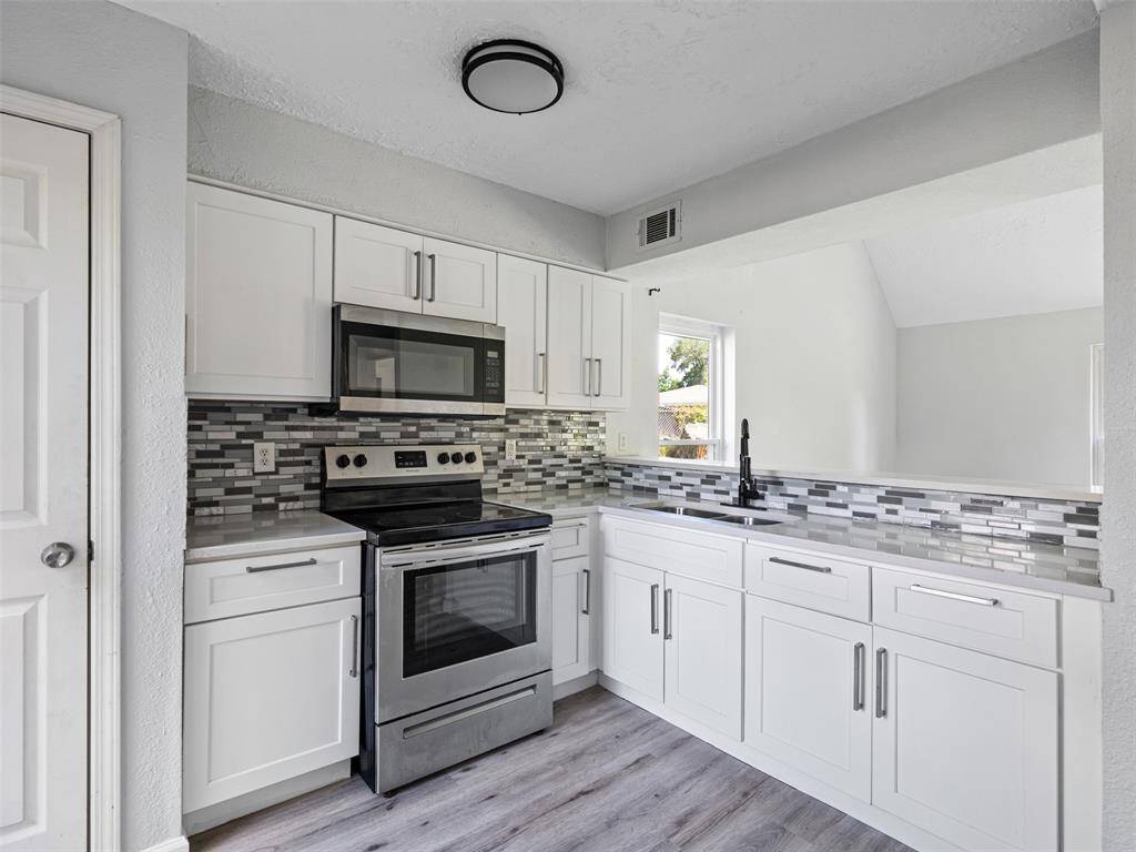Fully updated kitchen featuring new cabinets, sleek countertops, and modern flooring—ready for home cooking and hosting.