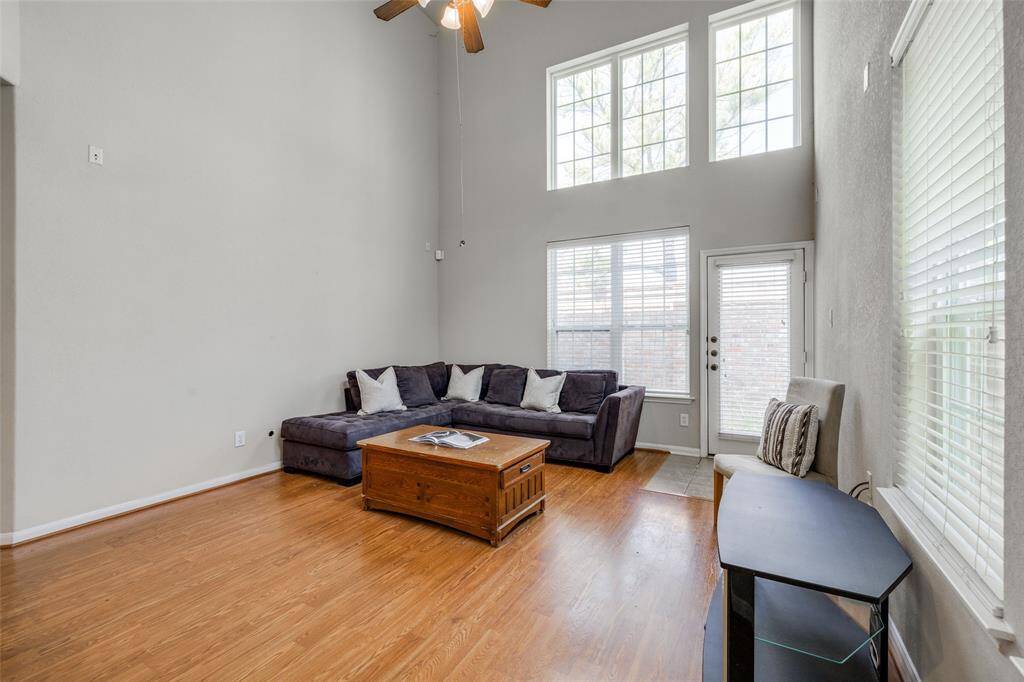 Living Room with wood floors, high ceilings, 2 inch blinds for privacy. Back door leading out to small back yard.