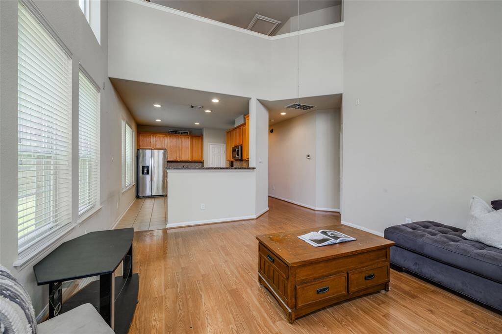 Living Room with wood floors, high ceilings, 2 inch blinds for privacy. Open plan through to the kitchen