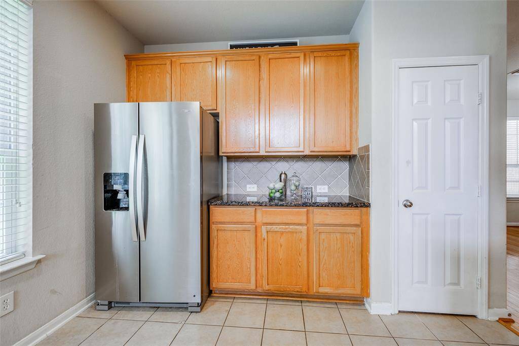 Large kitchen with lots of cabinets, walk in pantry, SS refrigerator,  granite counter tops & tile back splash