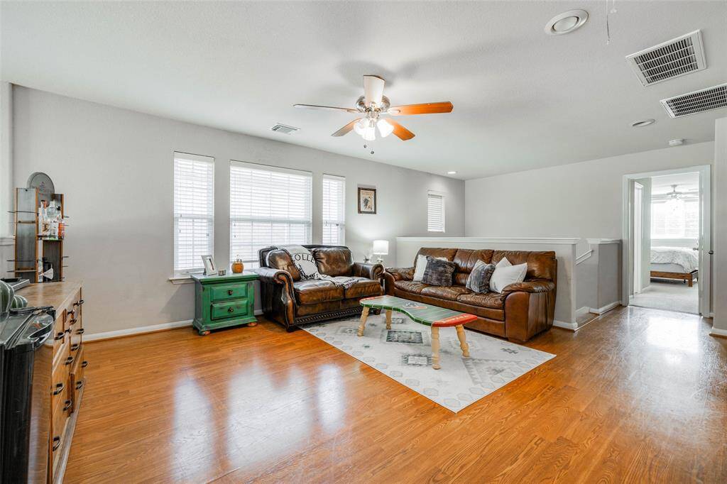 Spacious Game room located upstairs featuring wood floors, lots of natural light, 2 in blinds & ceiling fan.