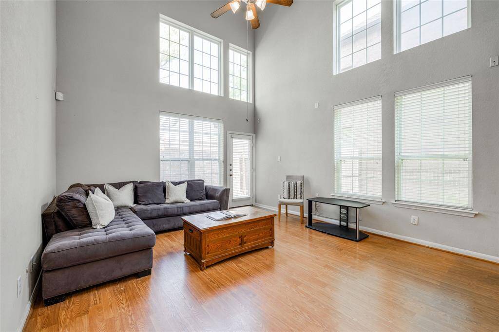 Living Room with wood floors, high ceilings, 2 inch blinds for privacy. Back door leading out to small back yard.