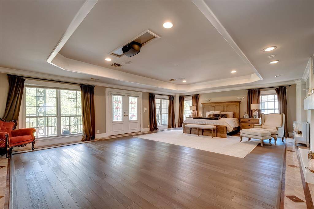 Luxurious master bedroom with a private balcony offering stunning views of the pool and backyard.