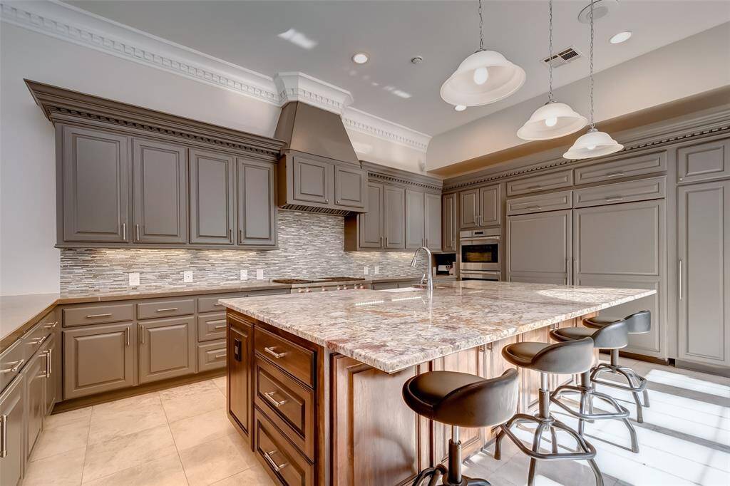 Experience luxury cooking with premium Wolf appliances and a state-of-the-art stove in this elegant kitchen.