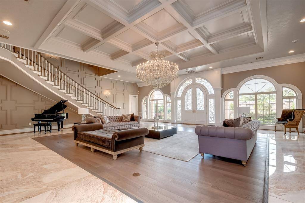 Experience elegance in this grand room with stunning arched windows, complemented by exquisite wood and marble flooring.